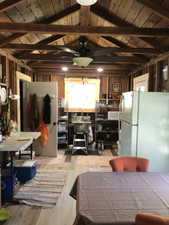 Open-concept room featuring exposed wood beam ceilings and wood-finish flooring