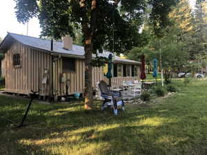 Exterior featuring vertical board siding, a corrugated metal roof, and a chimney