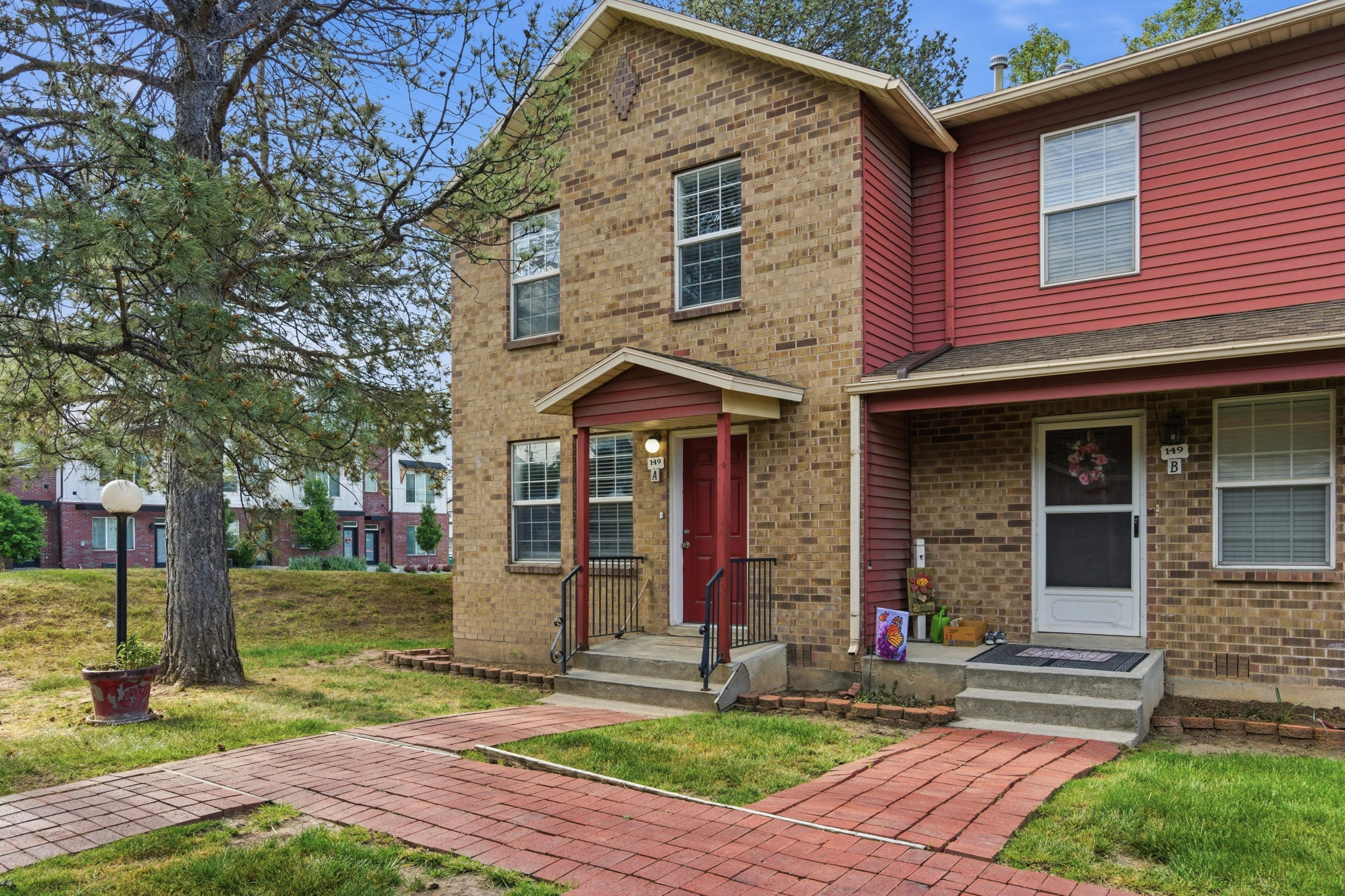 Brick and siding exterior featuring individual red brick pathways