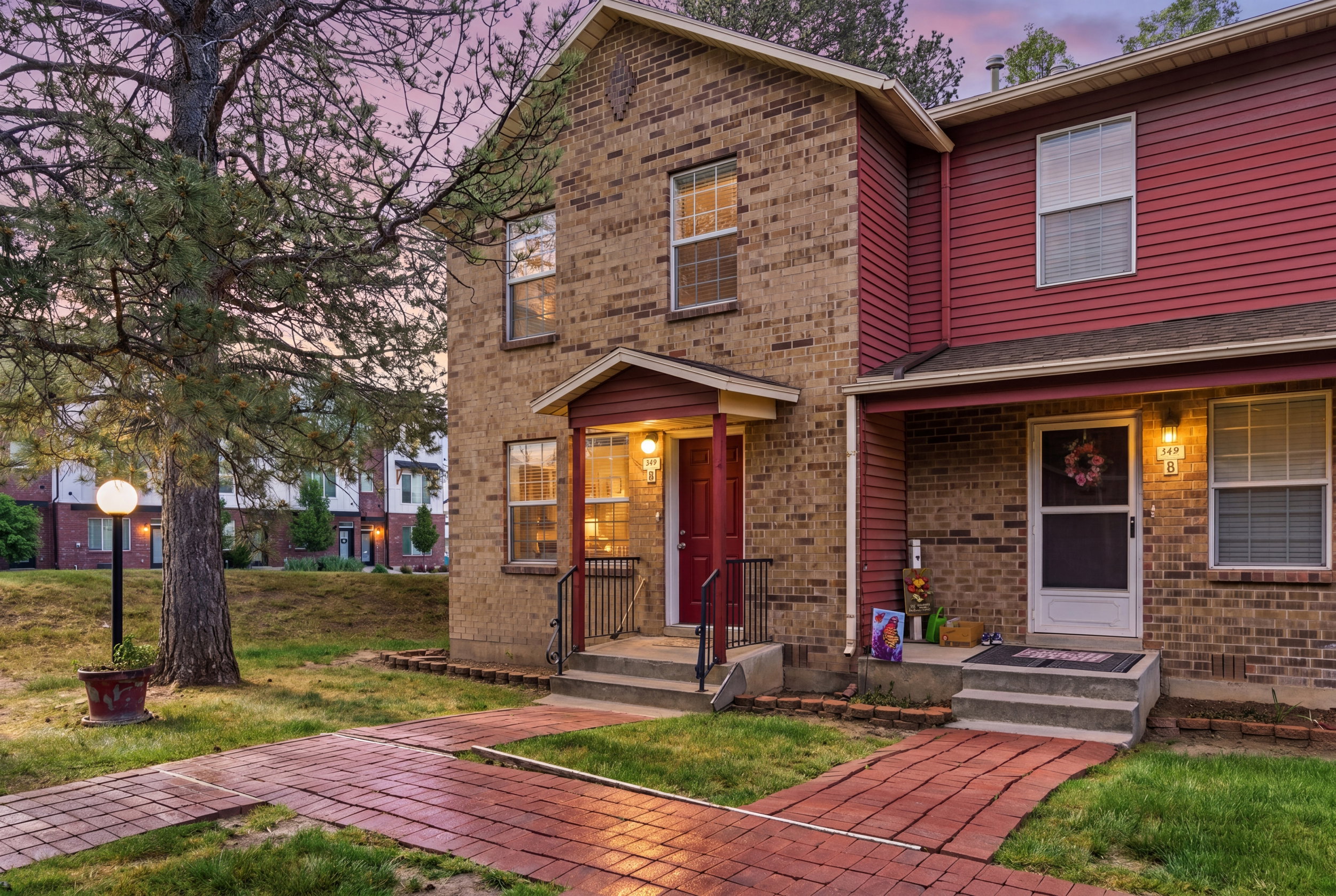 Brick and siding exterior featuring a covered entryway with a red door