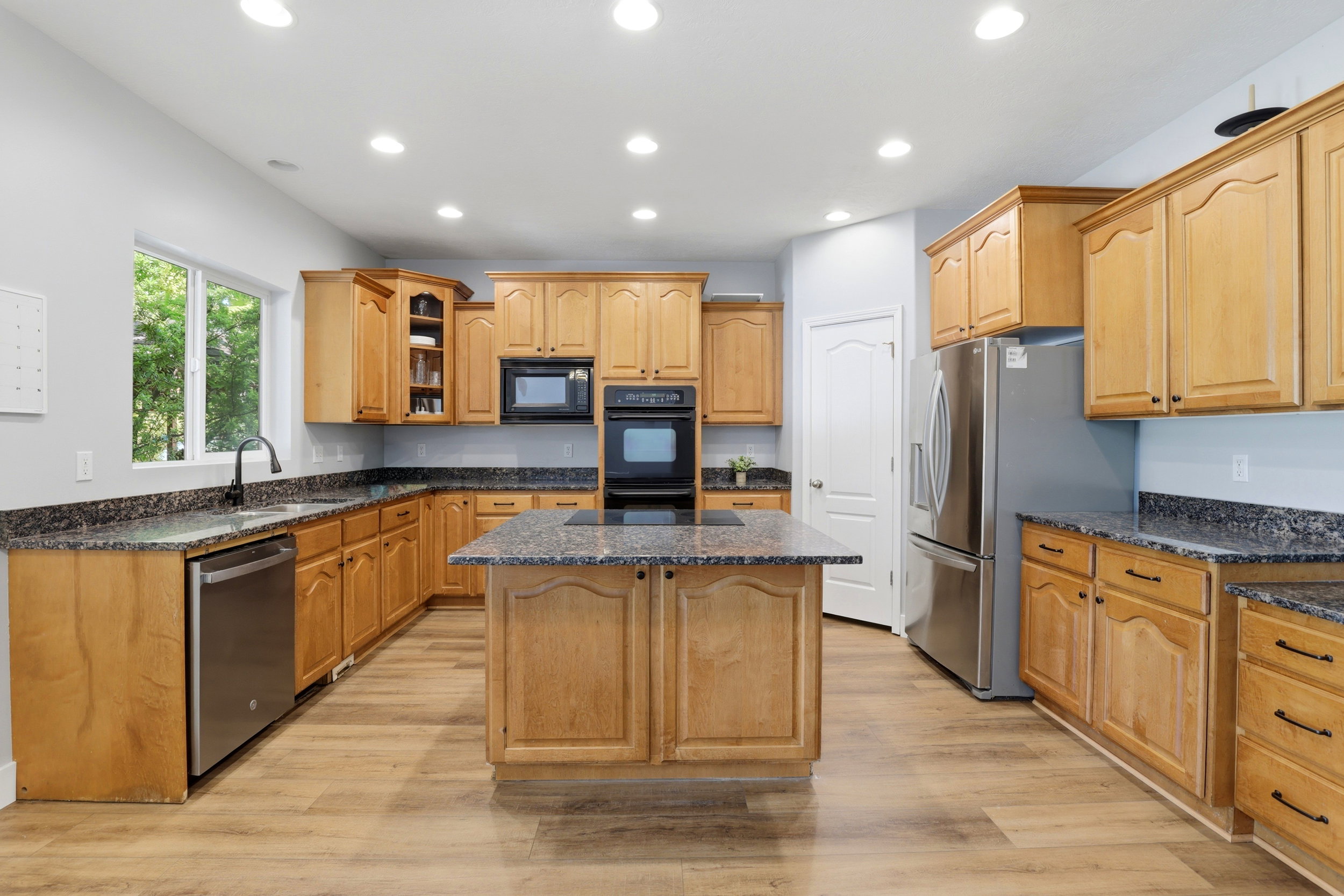 Kitchen featuring wood-finish flooring, recessed lighting, and light wood cabinetry with dark hardware