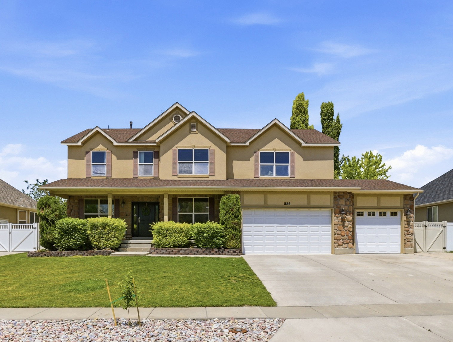 Stucco exterior home with stone accents and a covered front porch