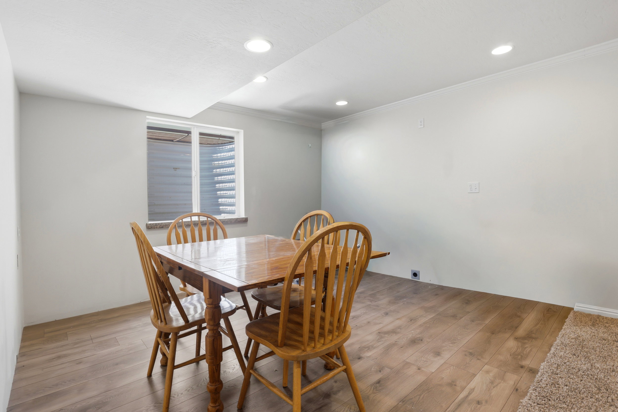 Recessed lighting illuminates this room featuring wood-finish flooring and a white ceiling