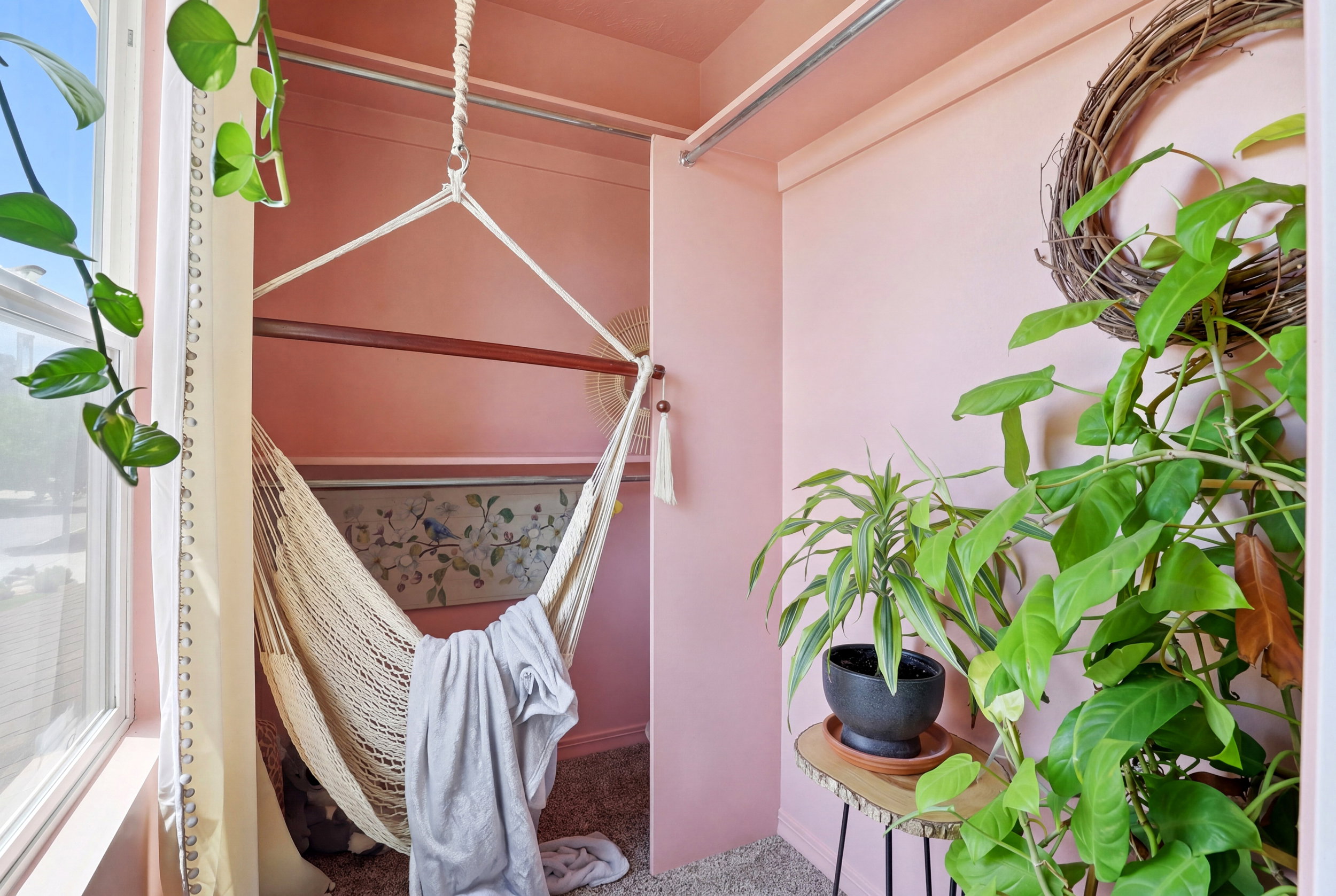 Recessed nook with soft pink walls and a textured woven hammock