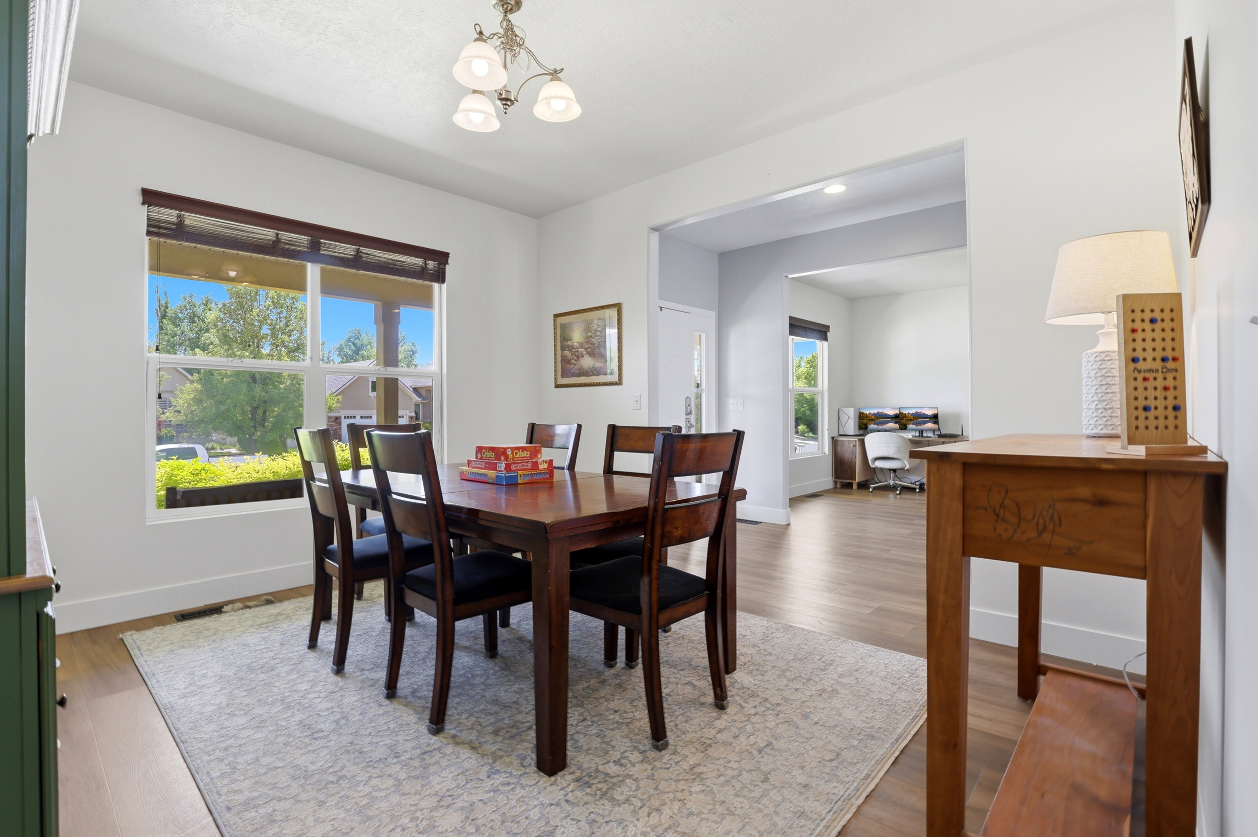 Dining area featuring a contemporary chandelier and large window with blinds