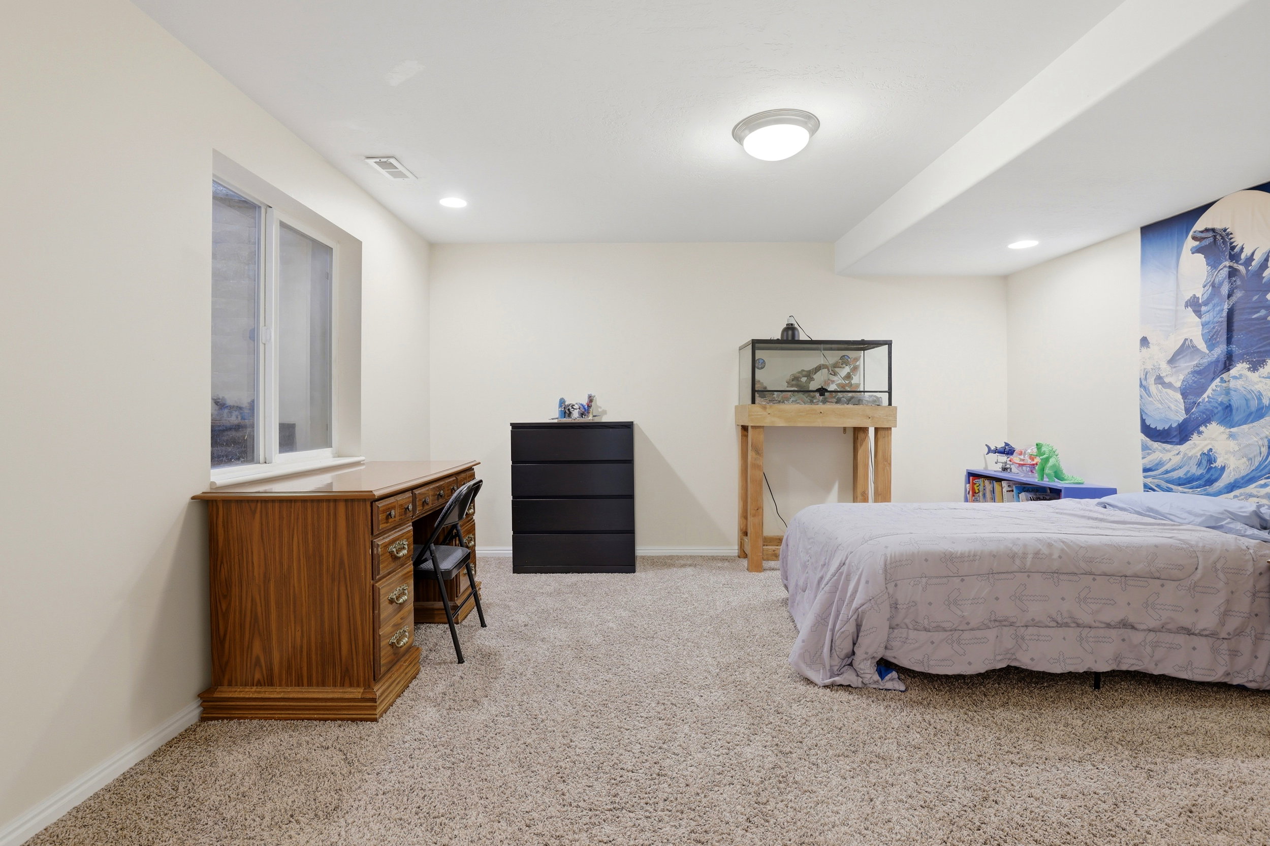 Spacious room with plush carpet, neutral wall tones, and recessed lighting