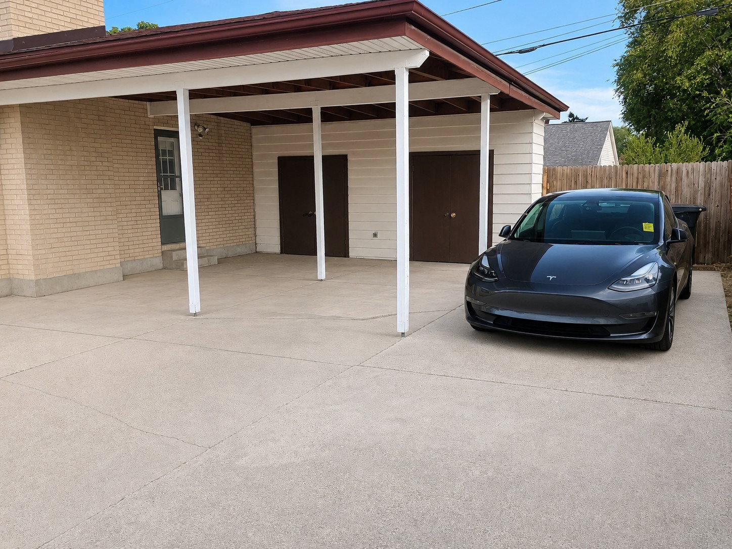 Carport with an extended concrete pad, offering sheltered parking