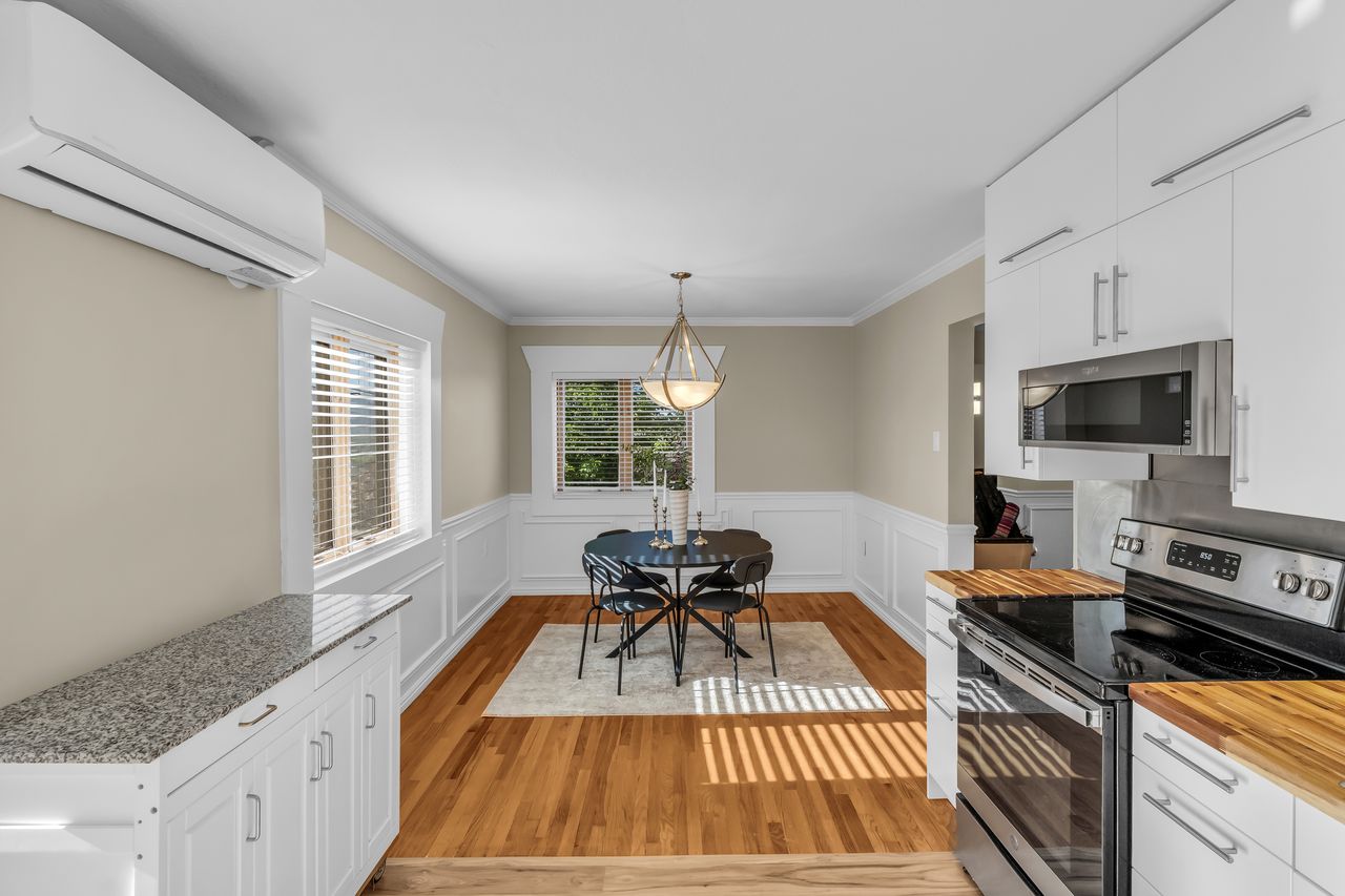 Dining area featuring wood-finish flooring, wainscoting, and crown molding