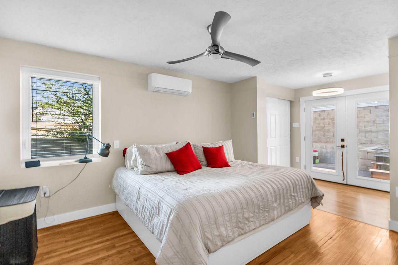 Bedroom featuring wood-finish flooring, a contemporary ceiling fan, and a mini-split HVAC unit