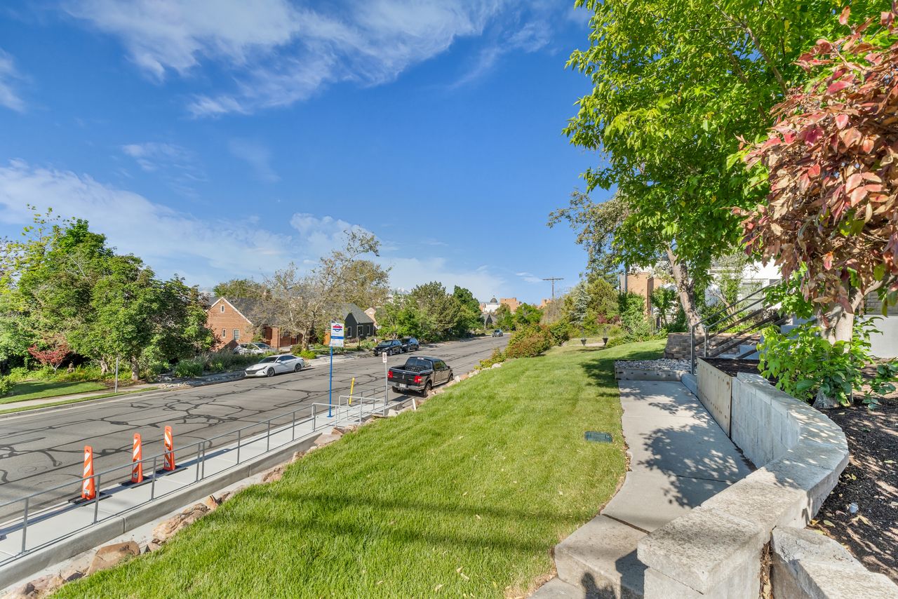 Manicured lawn with mature trees and a concrete retaining wall