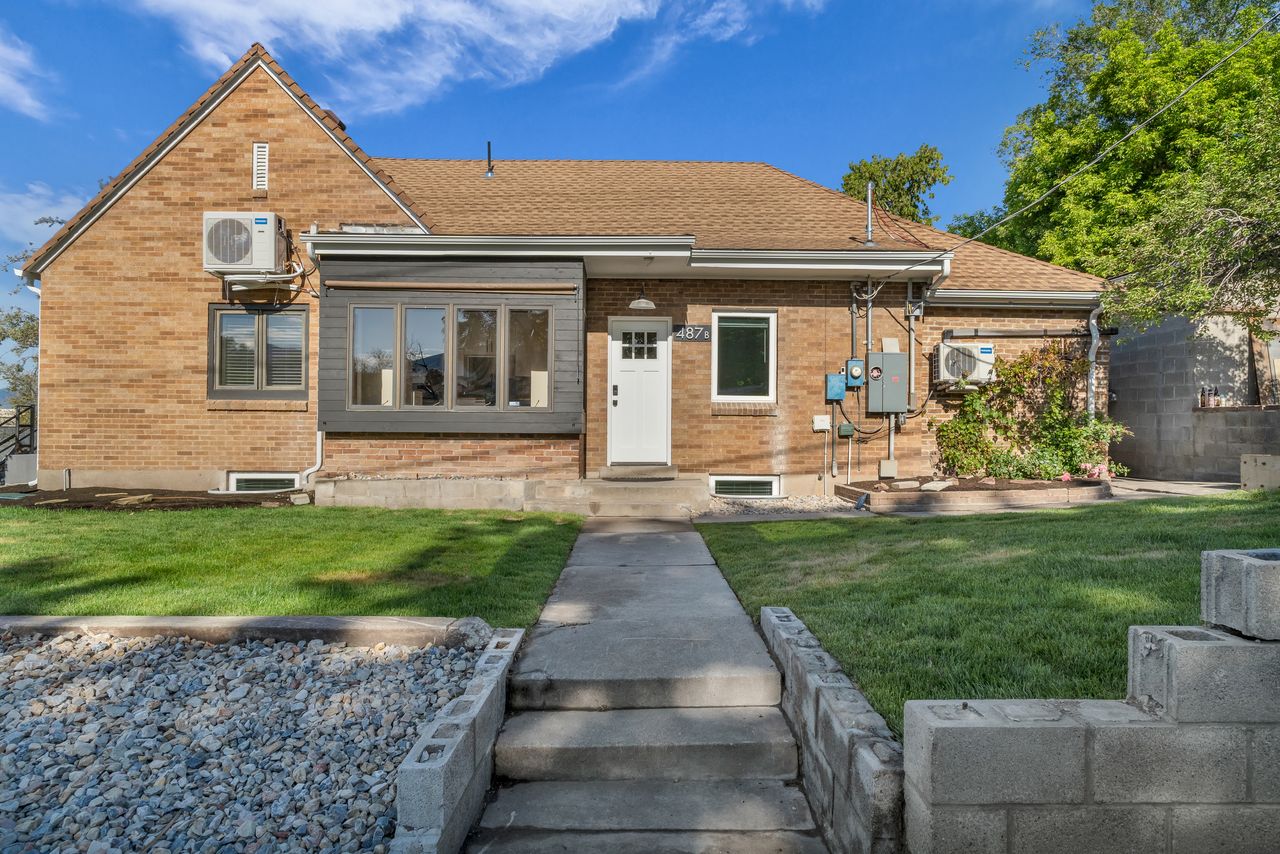 Brick exterior featuring a gabled roofline and a front bay window with dark siding
