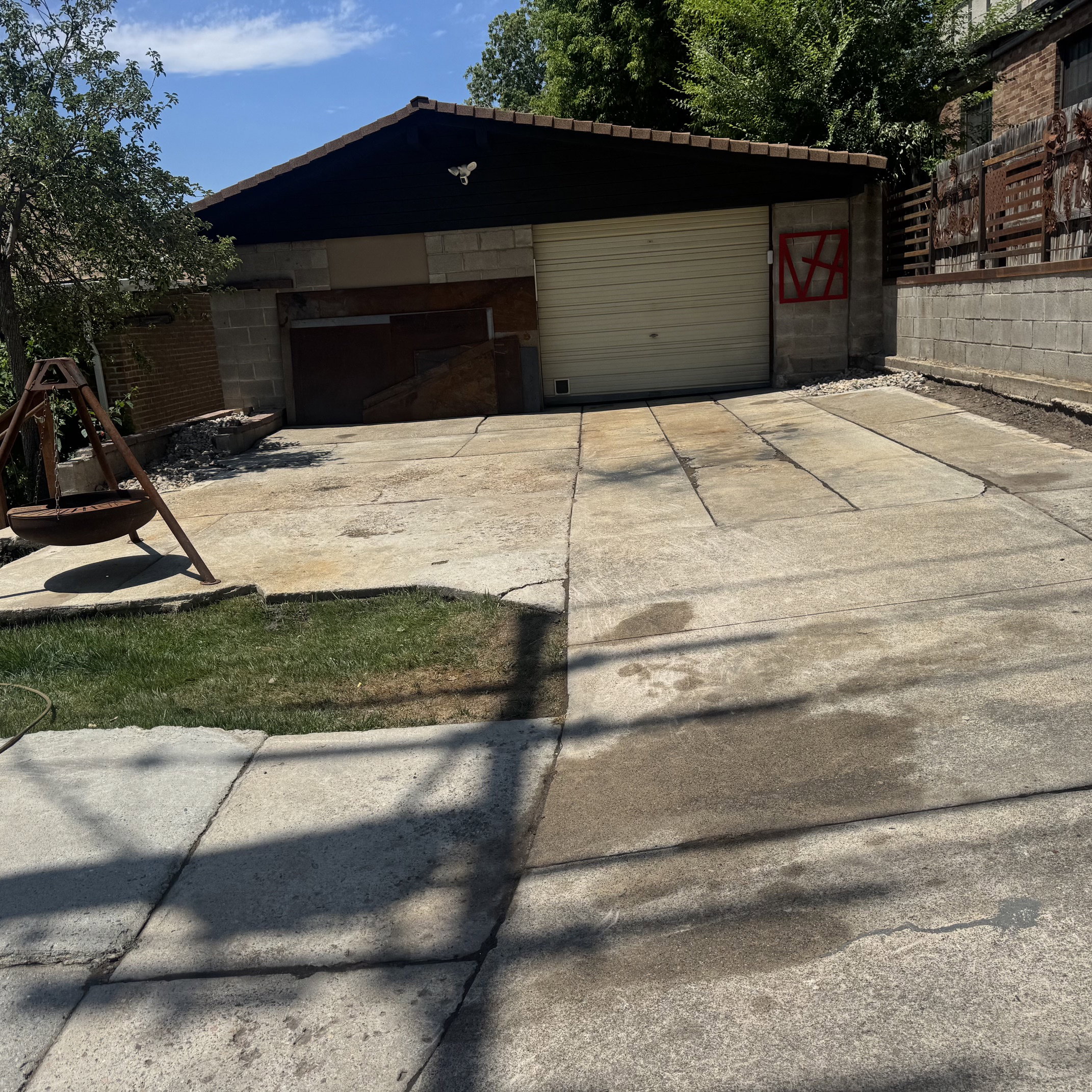 Detached garage structure with a concrete block base, a light-colored roll-up garage door, and an additional smaller entry