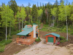 Rustic-style residence featuring a metal roof, wood siding, and an expansive wraparound deck
