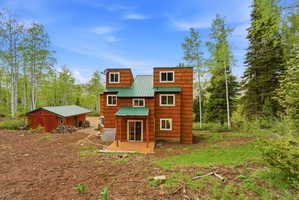 Multi-level residence featuring wood-shingle siding and a green metal roof