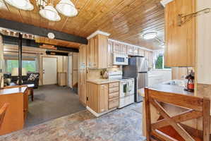 Kitchen featuring wood-finish cabinetry, stainless steel appliances, and a tiled backsplash