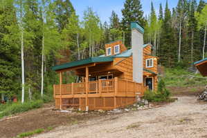 Wood-sided exterior featuring a covered porch with wood railing