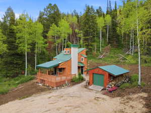 Wood-sided residence with green metal roofing and a covered porch