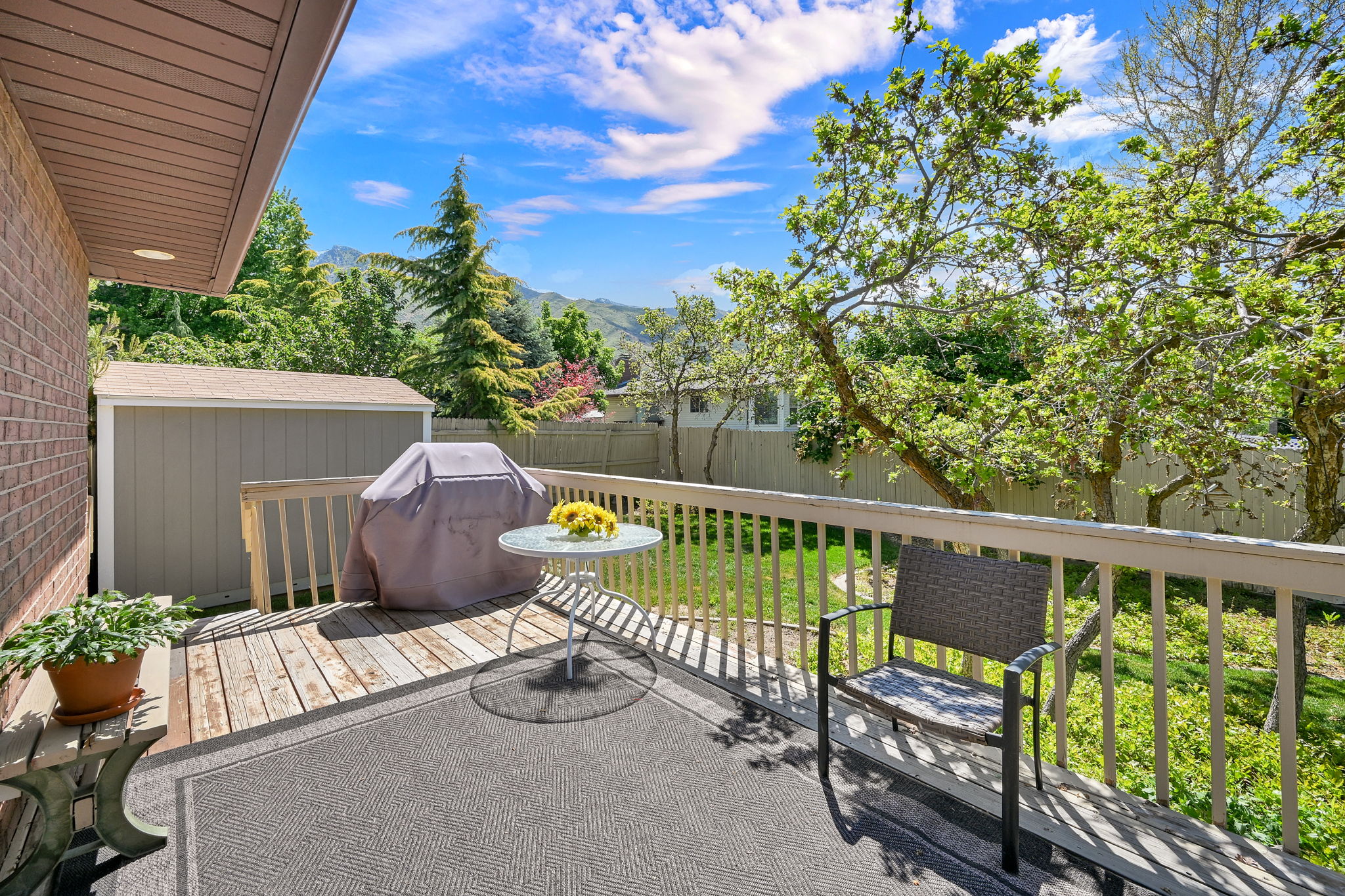 Wood deck with perimeter railing and a shaded overhang off the kitchen