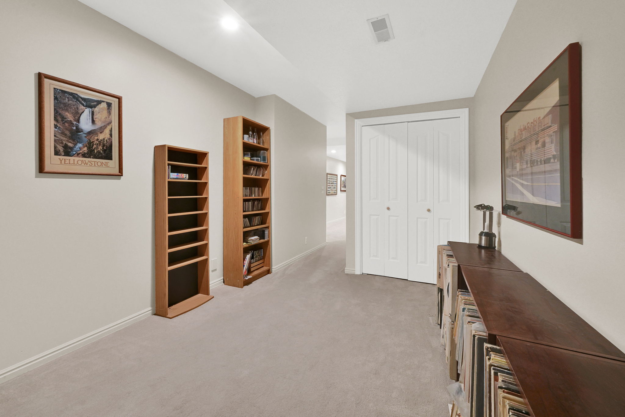 Hallway flex area featuring light gray carpeting, neutral wall paint, and white trim