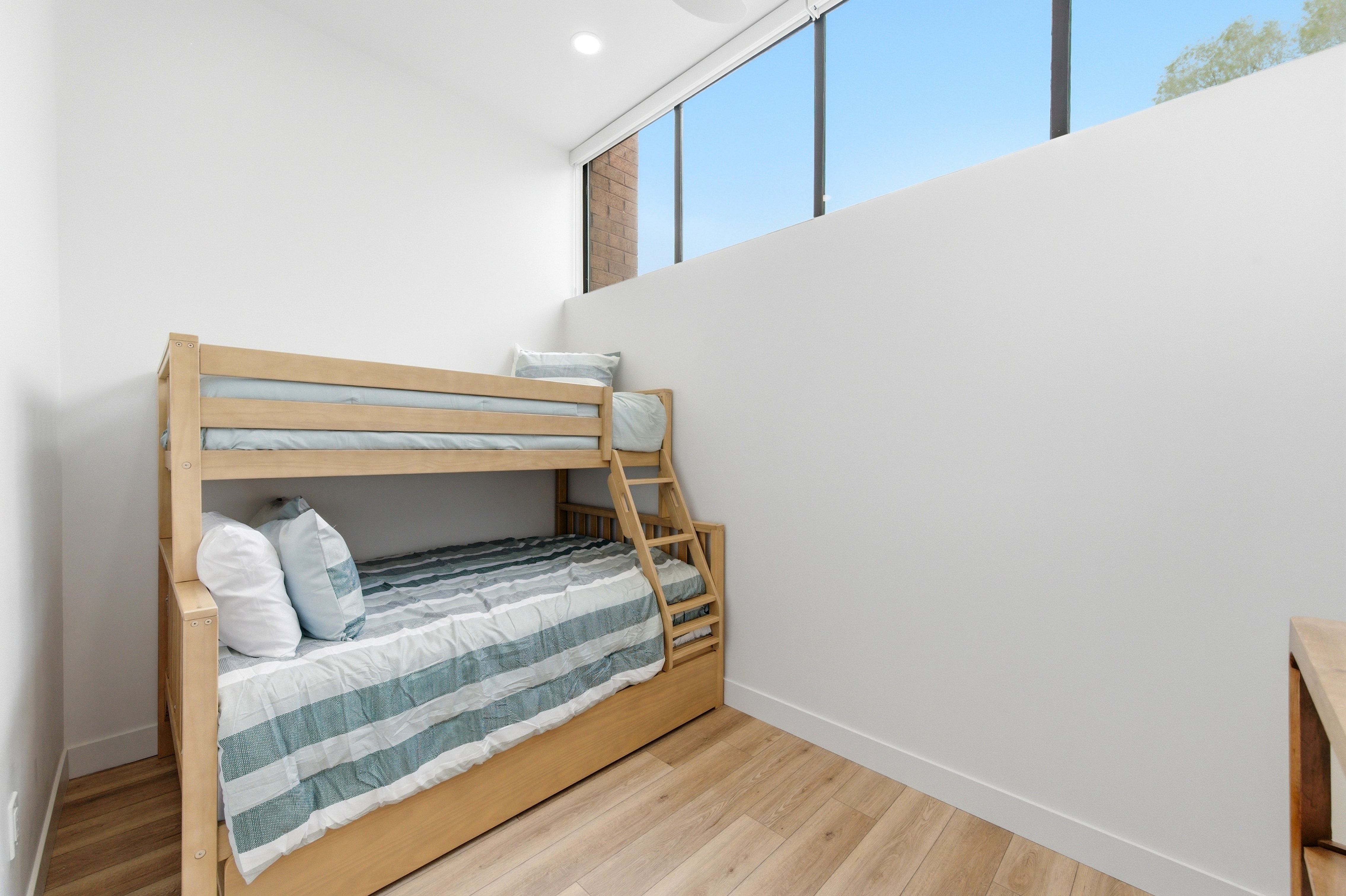 Room featuring light wood-finish flooring, white walls, and a high horizontal window