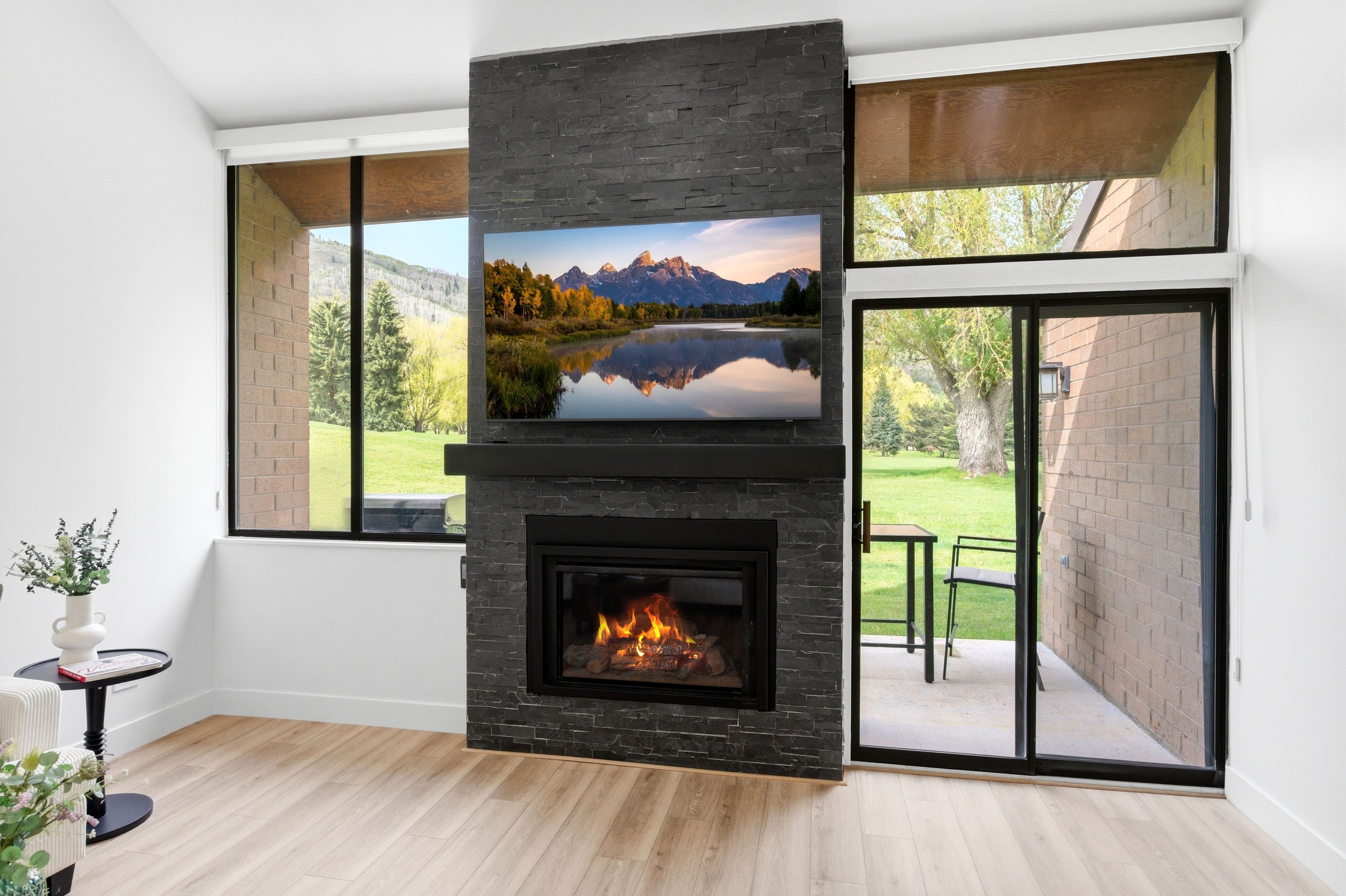 Fireplace with a stone surround and hearth, featuring a built-in television above