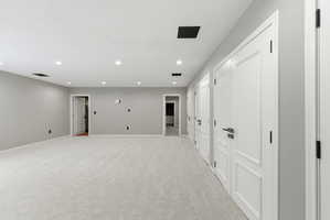 Spacious room featuring light gray walls and recessed lighting