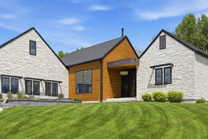 Contemporary exterior featuring a combination of light-colored stone veneer and warm wood siding