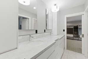 Dual vanity with undermount sinks, stone countertops, and chrome fixtures