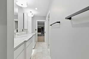 Double vanity with undermount sinks, stone countertop, and tile backsplash