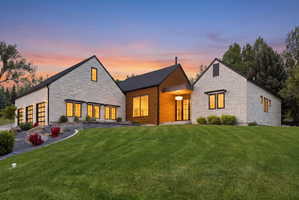 Contemporary stone and wood-clad exterior with multiple gables