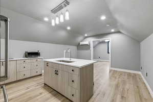 Kitchen area featuring light wood-finish flooring and sloped ceilings
