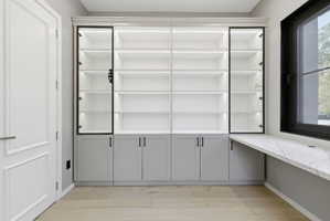 Custom built-in shelving with integrated lighting and glass-front display cabinets