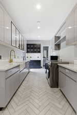 Laundry area featuring herringbone tile flooring, recessed lighting, white stone countertops, and light gray cabinetry