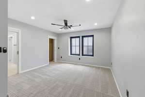 Spacious room featuring light gray walls and a patterned carpet