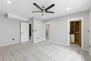 Spacious room featuring light gray walls, patterned carpeting, recessed lighting, and a modern ceiling fan