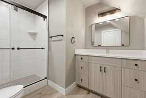 Modern bathroom featuring a spacious walk-in shower with black-framed glass doors, white tiled walls, and a built-in corner shelf