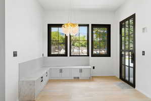 Entryway featuring light wood-finish flooring and a built-in L-shaped bench with a light-toned countertop