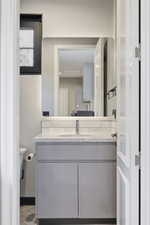 Modern vanity featuring a light gray cabinet with a white countertop and integrated sink