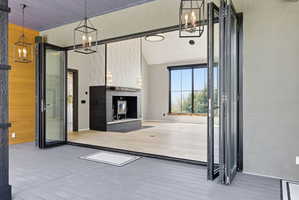 Expansive bi-fold glass doors opening to a covered porch with plank flooring