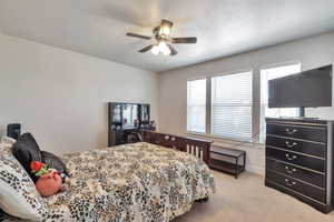 Bright interior space featuring a ceiling fan with integrated lighting, multiple windows with blinds, light-colored walls, and carpet flooring