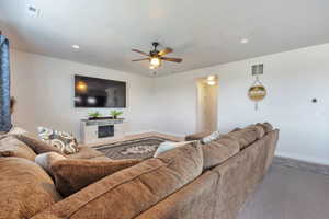 Living area with light-toned walls, recessed lighting, and a ceiling fan