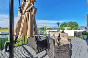 Spacious elevated deck featuring composite decking, black metal railings, and mountain scenery