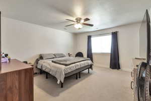 Carpeted bedroom featuring a ceiling fan with integrated lighting, a window with blinds, and white walls