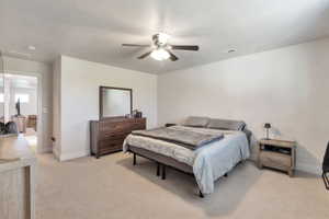 Carpeted room featuring a ceiling fan with integrated lighting, white walls, and a doorway leading to an additional space
