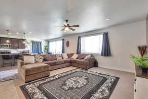 Open-concept living space featuring neutral carpet flooring, recessed lighting, and a ceiling fan