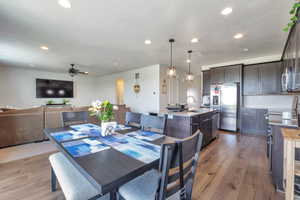 Dining area featuring wood-finish flooring, recessed lighting, and a dark wood table
