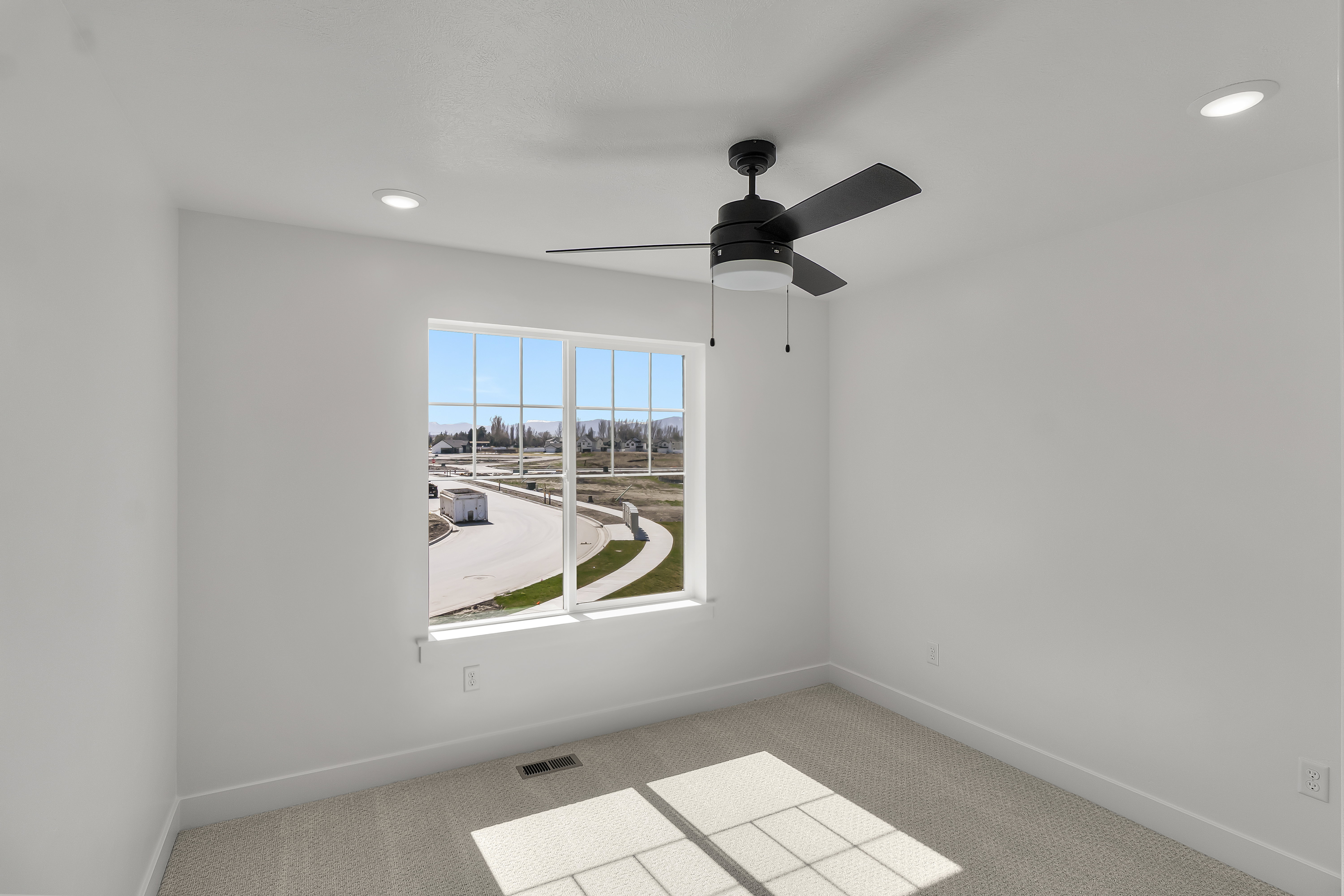 Bright room with a large window, recessed lighting, and a ceiling fan