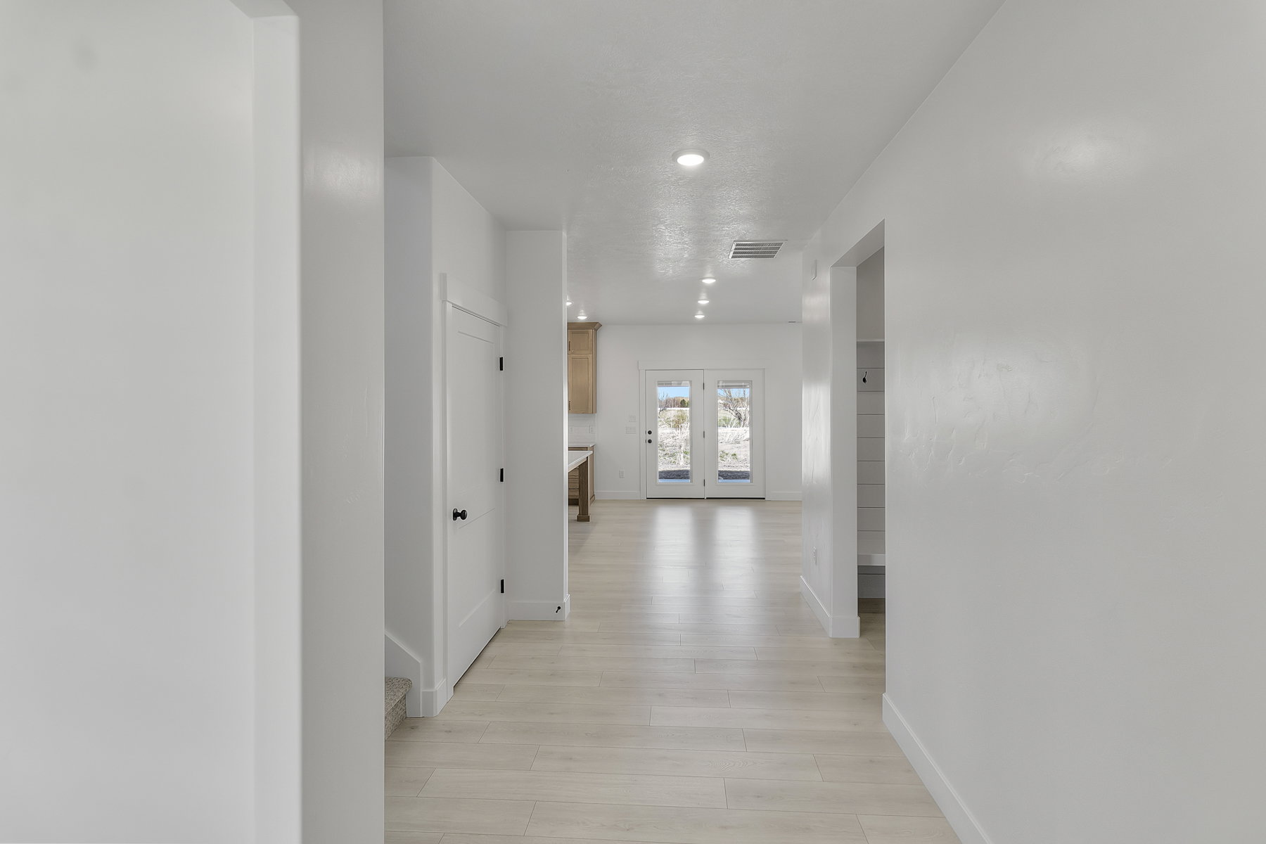 Hallway featuring light wood-finish flooring, recessed lighting, and white walls