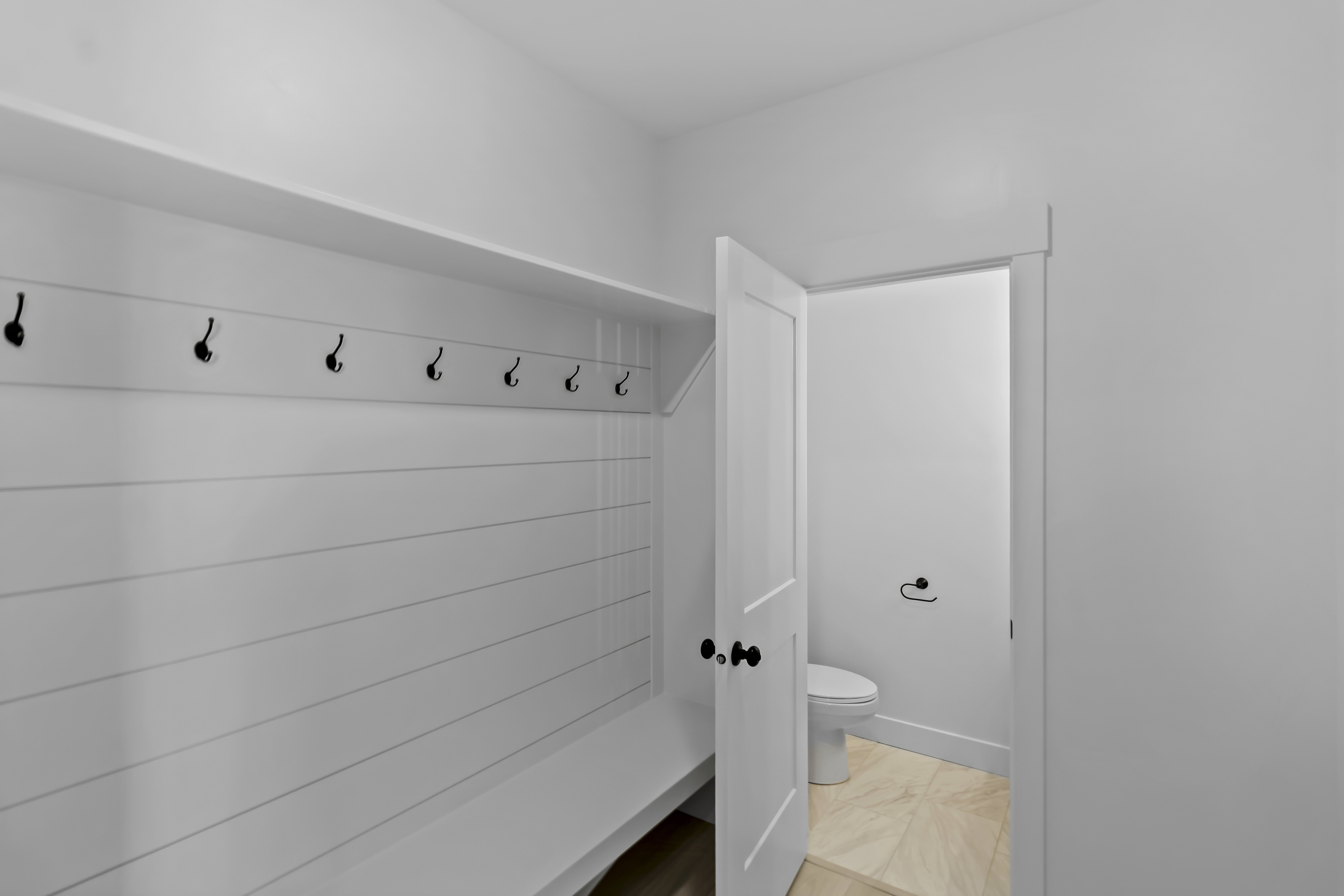 Built-in bench with shiplap backing and coat hooks