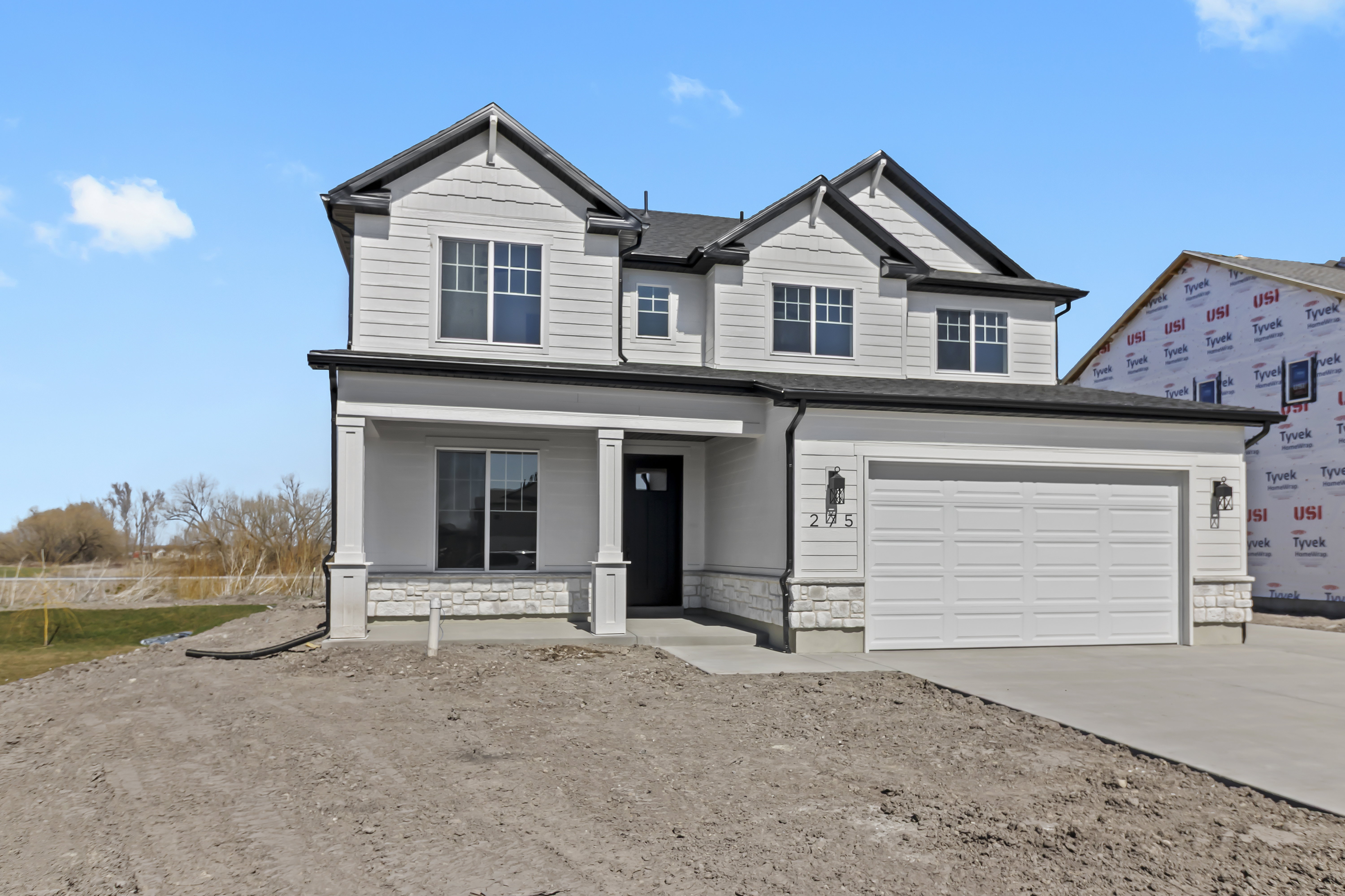 Modern two-story residence with white siding and dark trim accents
